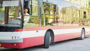elegant-driver-sitting-shuttle-bus-smiling-camera-summer-day-front-view-happy-man (1)