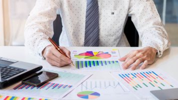 working-process-startup-businessman-working-wood-table-with-new-finance-project-modern-notebook-table-pen-holding-hand (1)